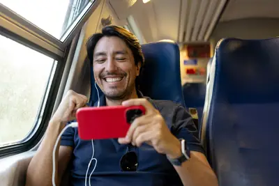A man watching video on his phone during a train commute